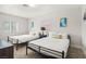 Two twin beds with metal frames, neutral bedding, and colorful pillows at 3784 Pama Ln, Las Vegas, NV 89120