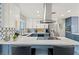L-shaped kitchen with white and blue cabinets, quartz countertops and stainless steel appliances at 3784 Pama Ln, Las Vegas, NV 89120