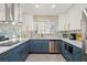Modern kitchen with white and blue cabinetry, stainless steel appliances, and a quartz island at 3784 Pama Ln, Las Vegas, NV 89120