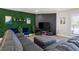 Living area with sectional sofa, green wall, and geometric-patterned wall at 3784 Pama Ln, Las Vegas, NV 89120