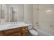 Bright bathroom with a wooden vanity, white sink, toilet, and shower-tub combination at 7145 Cypress Run Dr, Las Vegas, NV 89131