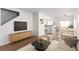Open-concept living area with wood floors, sleek furniture, and seamless flow to the kitchen and dining at 9333 Leaping Deer Pl # 102, Las Vegas, NV 89178