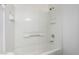 A clean, white tiled shower and tub combination provides a bright and simple bathroom space at 9333 Leaping Deer Pl # 102, Las Vegas, NV 89178
