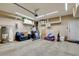 An organized garage with ample storage, including shelving, and a full-sized couch for relaxation at 5301 Fairbranch Ln, Las Vegas, NV 89135