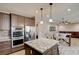 Gourmet kitchen with granite island, stainless appliances, and view to dining area at 5301 Fairbranch Ln, Las Vegas, NV 89135