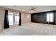 Spacious bedroom featuring plush carpeting, a ceiling fan, a large window, and access to the outdoor balcony at 5301 Fairbranch Ln, Las Vegas, NV 89135