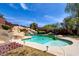 The backyard showcases a refreshing pool with rock features, lush landscaping, and space for outdoor entertaining at 5301 Fairbranch Ln, Las Vegas, NV 89135