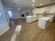 Open kitchen features island, white cabinets, and hardwood floors at 1335 Temporale Dr, Henderson, NV 89052