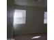 Sunlight filters through the blinds of two windows, casting shadows in the neutral-toned bedroom at 3505 Benson Ln, North Las Vegas, NV 89032