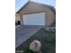 Tan home showcasing the two car garage, concrete driveway, and partial rock landscaping at 3505 Benson Ln, North Las Vegas, NV 89032