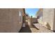 View of a sideyard with gravel and a paver walkway and wrought-iron gate at 3505 Benson Ln, North Las Vegas, NV 89032