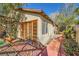 Home exterior displaying a brick pathway, stucco siding, and wooden doors at 4745 Desert Vista Rd, Las Vegas, NV 89121