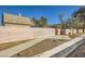 Backyard view showcasing concrete driveway, a stone perimeter wall, and a functional outdoor grill at 4745 Desert Vista Rd, Las Vegas, NV 89121
