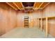 Unfinished basement featuring exposed wood beams, plywood walls, and a small shelf at 4745 Desert Vista Rd, Las Vegas, NV 89121