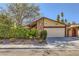 Charming single-story home featuring a stone facade, mature landscaping, and an attached two-car garage at 4745 Desert Vista Rd, Las Vegas, NV 89121