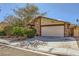 Traditional home showcasing a stone facade, manicured shrubbery, and a two-car attached garage at 4745 Desert Vista Rd, Las Vegas, NV 89121