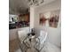 View of the eat-in kitchen area with tile floors, a glass table, white chairs, and a view of the rest of the kitchen at 4037 Gliding Gulls Ave, North Las Vegas, NV 89084