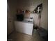 A well-organized laundry room with washer, dryer, storage shelves, and tile flooring at 4037 Gliding Gulls Ave, North Las Vegas, NV 89084