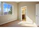 Bedroom with neutral carpet, paint, and trim, large picture window, and an en-suite bathroom at 3301 Rodeo Ave, Pahrump, NV 89048