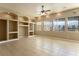 Bright living room features built-in shelving, a ceiling fan and natural light from multiple windows at 3301 Rodeo Ave, Pahrump, NV 89048