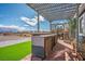 This outdoor kitchen has a charming pergola, bar seating, and brick flooring, perfect for entertaining guests at 3301 Rodeo Ave, Pahrump, NV 89048