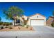 Tan house with a two-car garage and neatly landscaped yard at 3320 Kookaburra Way, North Las Vegas, NV 89084