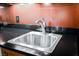 Close-up shot of the stainless steel sink with modern faucet on dark granite countertop at 135 E Harmon Ave # 3704, Las Vegas, NV 89109