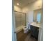 Clean bathroom with gray vanity, shower, and wood-look floors at 1448 Nocturnal Flight St, Las Vegas, NV 89138