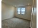 Bright bedroom with carpet flooring and two windows at 1448 Nocturnal Flight St, Las Vegas, NV 89138