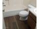 Bathroom with wood-look flooring, toilet, sink, and tub at 5049 Spencer St # D, Las Vegas, NV 89119