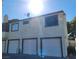 Two-story townhome showcasing private garages and neutral stucco exterior, capturing its functional design at 5049 Spencer St # D, Las Vegas, NV 89119
