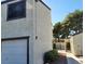 Side view of a townhome displaying the garage, stucco exterior, and landscape, accentuating the property's appeal at 5049 Spencer St # D, Las Vegas, NV 89119