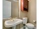 Small bathroom with pedestal sink, toilet and wood cabinet at 1860 E Ford Ave, Las Vegas, NV 89123