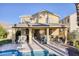 Resort-style backyard with a pool, covered patio, built-in bar, and lush landscaping at 1002 Prestige Meadows Pl, Henderson, NV 89052