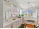 Bathroom featuring double sinks, soaking tub, and a walk-in shower at 1002 Prestige Meadows Pl, Henderson, NV 89052