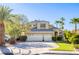 Charming two-story home with a three car garage, well-maintained lawn, mature trees, and desert landscaping at 1002 Prestige Meadows Pl, Henderson, NV 89052