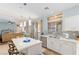 Open concept kitchen featuring white cabinets, a marble-top island with seating, and stainless steel appliances at 1002 Prestige Meadows Pl, Henderson, NV 89052