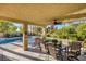 Covered patio featuring a dining table and chairs, perfect for outdoor entertaining by the pool at 1002 Prestige Meadows Pl, Henderson, NV 89052