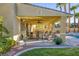 Outdoor living space with covered patio, dining set, and lush backyard view, ideal for relaxation and entertaining at 1002 Prestige Meadows Pl, Henderson, NV 89052