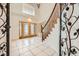 Grand entryway with tiled floors, wooden staircase, and decorative gate at 7668 Gossamer Wind St, Las Vegas, NV 89139