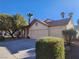 House exterior featuring a two-car garage and well-manicured landscaping at 841 Lusterview Ct, Las Vegas, NV 89123