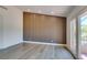 Light and airy bedroom featuring a wood accent wall and laminate wood flooring at 7132 Mission Hills Dr, Las Vegas, NV 89113