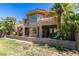 Two-story house with stucco exterior, large windows, and a patio, surrounded by palm trees and a manicured lawn at 7132 Mission Hills Dr, Las Vegas, NV 89113