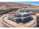 An aerial view of a luxury home under construction in a desert community, with scaffolding and mountain views at 12 Oakmont Hills Ln, Las Vegas, NV 89141