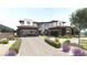 Beautiful modern home with stone accents, desert landscaping, and a brick driveway leading to two garages at 12 Oakmont Hills Ln, Las Vegas, NV 89141