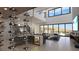 Modern living room with sleek furnishings, wine storage, and expansive windows offering views of the pool at 12 Oakmont Hills Ln, Las Vegas, NV 89141