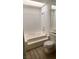 This bathroom features a shower-tub combo and toilet with wood-look floors at 2986 Juniper Hills Blvd # 202, Las Vegas, NV 89142