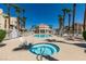 Community pool and spa with surrounding lounge chairs and palm trees at 5000 Red Rock St # 116, Las Vegas, NV 89118