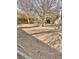 Sandy backyard with mature trees and exposed roots at 9917 Aspen Knoll Ct, Las Vegas, NV 89117