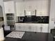 Modern kitchen featuring sleek black countertops, white cabinets, and stainless steel appliances at 2742 Kingclaven Dr, Henderson, NV 89044